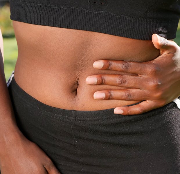 Person holding stomach after meal illustrating post-meal digestive pain and IBS symptoms
