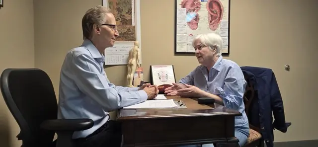 Steven Sonmore consulting with a patient about her health