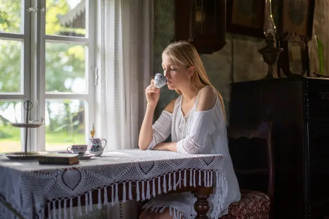 Woman relaxing with tea by a window